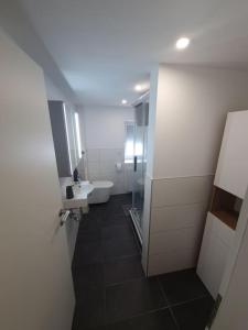 a bathroom with a sink and a toilet and a mirror at Ferienwohnung zur Fröhlichkeit in Oberaltertheim