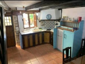 uma cozinha com um lavatório e uma bancada em Casa do Duende em Tejedo