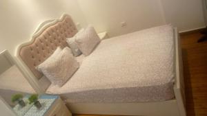 - une petite chambre avec un lit blanc et 2 oreillers dans l'établissement شقة فاخرة علي البحر مباشرة لوران الاسكندرية, à Alexandrie