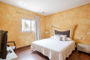 um quarto com uma cama grande e uma televisão em Villa Moderna em Chiva