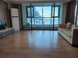 uma sala de estar com um sofá e uma televisão em Ocean & sunrise View-10 seconds of beach walk - Three bedrooms em Goseong