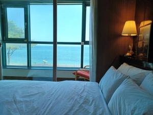 um quarto com uma cama e vista para o oceano em Ocean & sunrise View-10 seconds of beach walk - Three bedrooms em Goseong