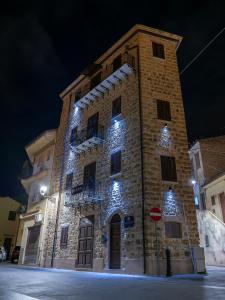 a large stone building with lights on it at night at La Torre in Santo Stefano di Camastra