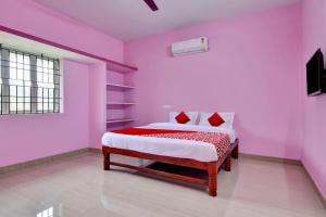 清奈的住宿－Hotel S P Stay'S，卧室拥有粉红色的墙壁,配有一张带红色枕头的床