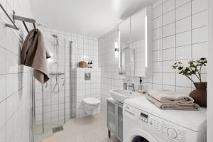 a white bathroom with a washing machine and a sink at Unique Oslo/Vika Apartment in Oslo