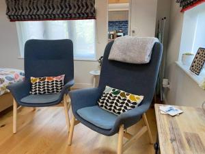 2 sillas con almohadas en una habitación en Cliff Lane Annexe: stylish in a perfect location., en Cromer