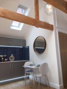 a kitchen with a table and chairs and a mirror at Cliff Lane Annexe: stylish in a perfect location. in Cromer