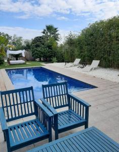 奇瓦的住宿－Villa Moderna，两个蓝色长椅,位于游泳池旁