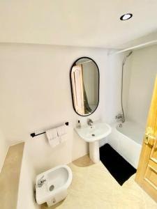 a white bathroom with a sink and a mirror at Appartement au cœur de Rabat in Rabat