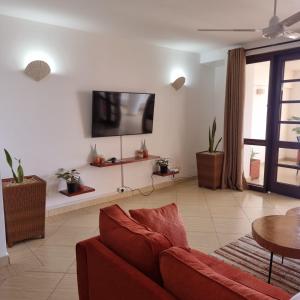 a living room with a couch and a flat screen tv at Ocean View Apartment D5 in Mombasa