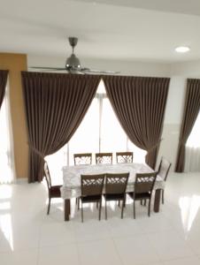 a dining room with a table and chairs and windows at Pinevalley Homestay Putrajaya Presint 12 in Putrajaya