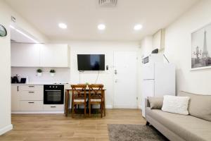 a kitchen and living room with a couch and a table at המלך גורג סוויטה in Jerusalem