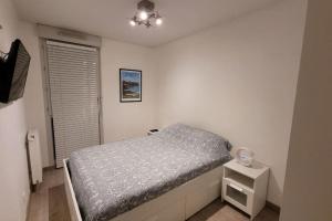 リヨンにあるAppartement Voie Lactée Lyonのベッドとナイトスタンドのある小さな寝室