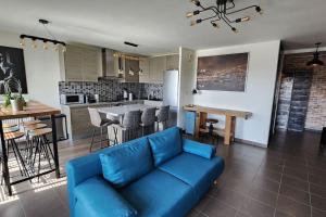 リヨンにあるAppartement Voie Lactée Lyonの青いソファとキッチンのあるリビングルーム