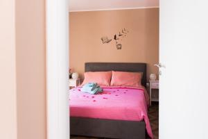 een slaapkamer met een roze bed met vogels aan de muur bij Palazzo DE MATTEO in Caiazzo