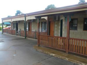 an old building with a porch and a building with a porch at Curtain Fig Motel in Yungaburra