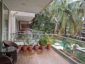 卡蘭古特的住宿－Goan Fiesta 1BHK Pool View at Eternal Wave CALANGUTE，一个带盆栽植物的阳台和一个游泳池