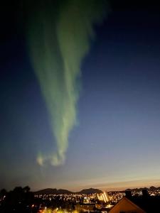 una imagen de una aurora en el cielo por la noche en Sentral og koselig leilighet, en Tromsø
