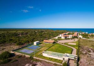 an aerial view of a house with a tennis court and the ocean at Carneiros Beach Resort in Praia dos Carneiros