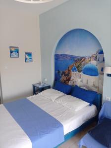a bedroom with a large bed with a painting on the wall at Victoria's Blue studios in Siviri