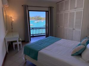 1 dormitorio con cama y vistas al agua en Grand Baie Beach Penthouse, en Grand Baie