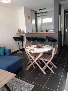 a living room with a table and chairs and a kitchen at Les clés du sud sauvage in Saint-Joseph