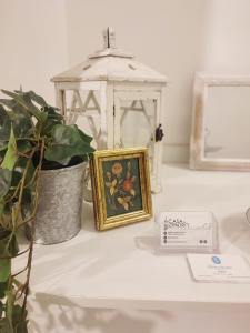 una mesa con una foto y una linterna y una planta en Casa in Centro Foggia en Foggia