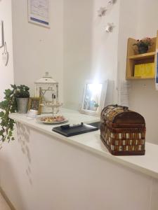 Un mostrador blanco con una mesa con una cesta. en Casa in Centro Foggia, en Foggia