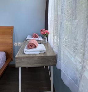 un tavolo in legno con asciugamani e fiori di Blue studio a Néa Michanióna
