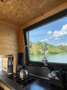 uma cozinha com uma grande janela sobre um fogão em AQUACHILL houseboat & wellness em Liptovský Trnovec