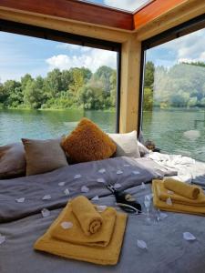 uma cama num barco com vista para um rio em AQUACHILL houseboat & wellness em Liptovský Trnovec