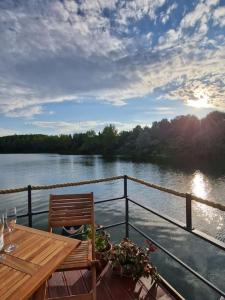uma mesa e um banco num barco num rio em AQUACHILL houseboat & wellness em Liptovský Trnovec