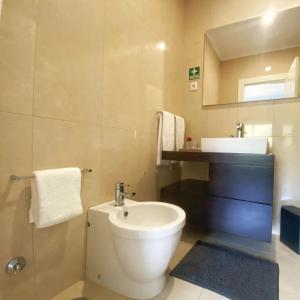 La salle de bains est pourvue de toilettes blanches et d'un lavabo. dans l'établissement VARANDA DO ABELHAL, à Baião