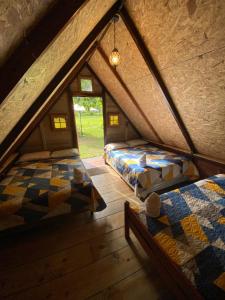 a attic room with two beds and a window at Casa Santa Teresita - Cabaña familiar tipo glamping in Sanarate