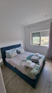 duże łóżko w sypialni z oknem w obiekcie VARANDA DO ABELHAL w mieście Baião