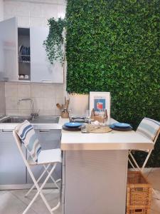 - une cuisine avec une table, des chaises et un mur vert dans l'établissement Casa in Centro Foggia, à Foggia