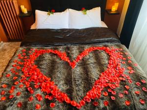 Una cama con un corazón hecho de flores rojas en Exotic spa, en Poissy
