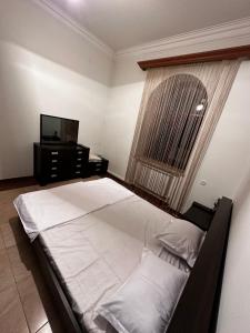una camera con un grande letto e una televisione di Home Martiros a Vagharshapat