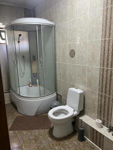 a bathroom with a shower and a toilet in it at Уютная вилла в центре Бишкека in Bishkek
