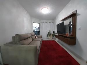 a living room with a couch and a red rug at Santa House no Centro in Santa Cruz do Sul