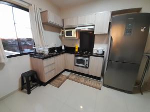 a kitchen with a stainless steel refrigerator and microwave at Santa House no Centro in Santa Cruz do Sul