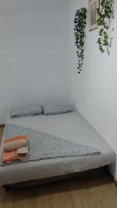 a bed in a room with a white wall at metro La Salut in Badalona
