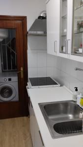 uma cozinha com um lavatório e uma máquina de lavar roupa em metro La Salut em Badalona
