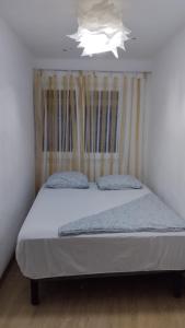 een bed in een kleine kamer met een wit plafond bij metro La Salut in Badalona