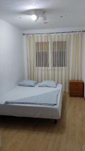 een slaapkamer met een bed en een houten vloer bij metro La Salut in Badalona