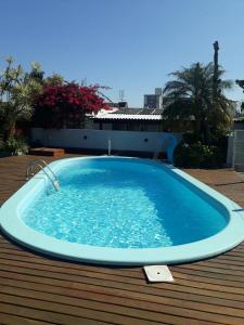 een groot blauw zwembad op een houten terras bij Santa House no Centro in Santa Cruz do Sul