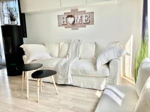 a living room with a white couch and two tables at VIP Lounge Villa - Parc expo - Le Bourget - Stade France in Mitry-Mory