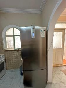 a stainless steel refrigerator in a kitchen with an archway at AC Rooms-Sea 100 meter in Antalya