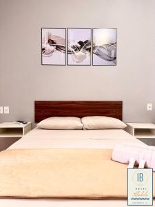 Hotel Residencial Ilhabela في فلوريانوبوليس: غرفة نوم بسرير بأربع صور على الحائط