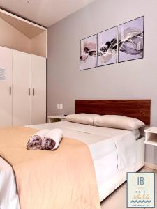 two beds in a bedroom with three pictures on the wall at Hotel Residencial Ilhabela in Florianópolis